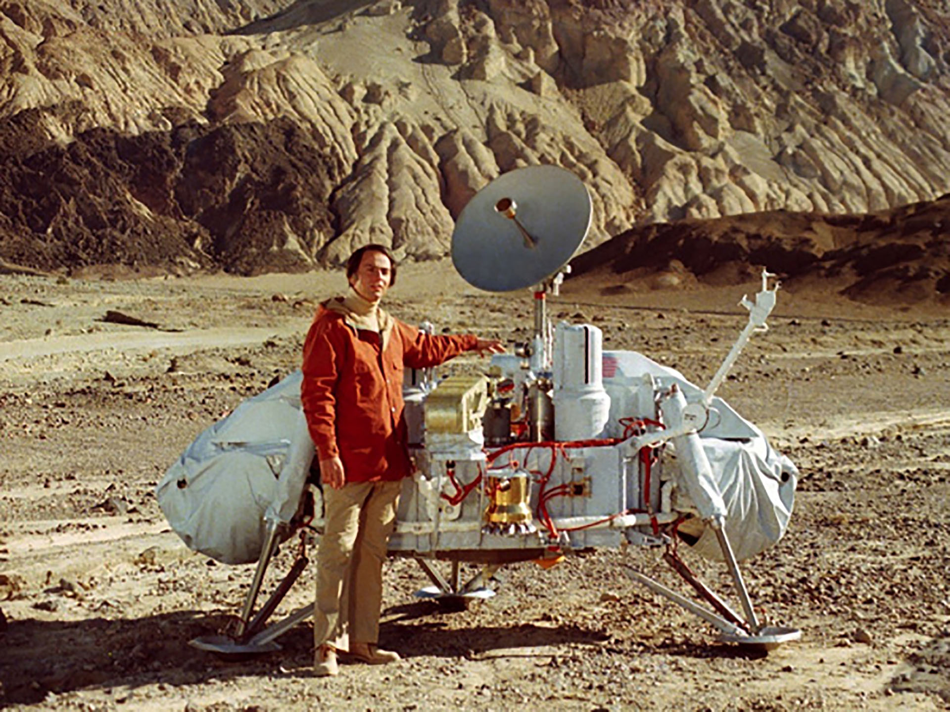 Carl Sagan with a spacecraft model